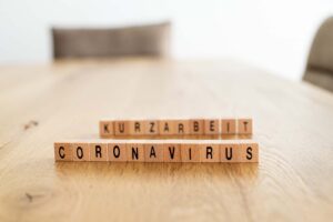 Tisch mit beschrifteten Würfeln "Coronavirus & Kurzarbeit"